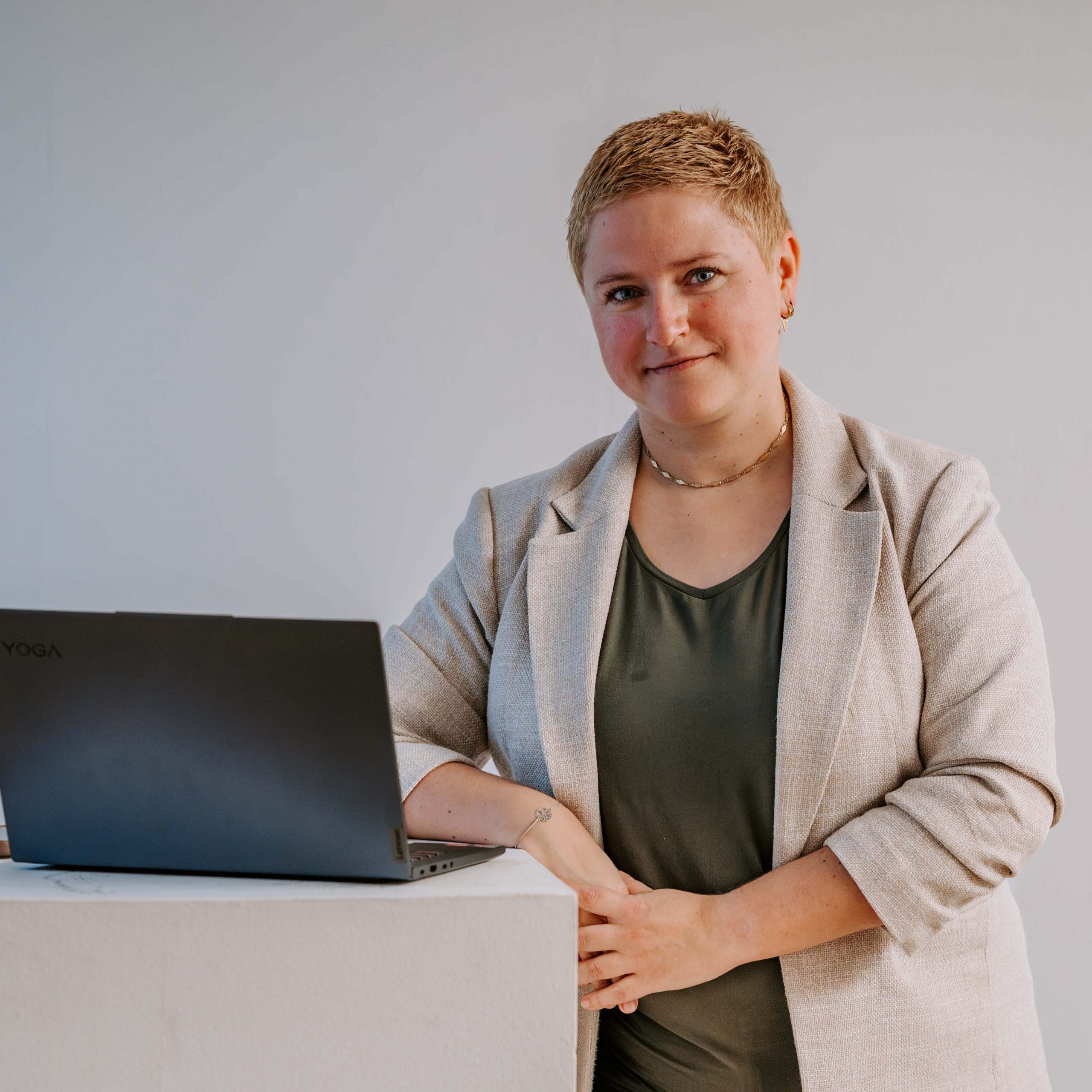 Online-Coaching: Coach Bea Schwaiger steht neben ihrem Notebook und schaut in die Kamera